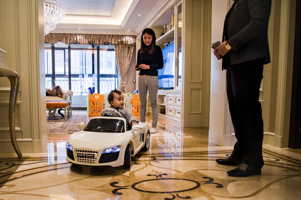 Shanghai (Cina), l'imprenditore Steven Zhu gioca con la moglie e il figlio piccolo, Radisson, in casa. 2014. © Alessandro Gandolfi